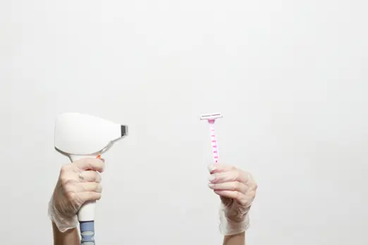 Hands in gloves comparing hair removal tools, with a pink disposable razor and a professional laser hair removal device, highlighting permanent back hair removal solutions for men.