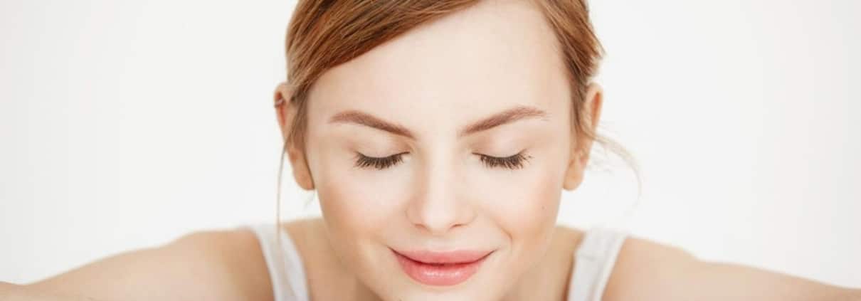 Woman with clear, glowing skin after exosomes facial treatment showing smooth texture and even tone