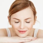 Woman with clear, glowing skin after exosomes facial treatment showing smooth texture and even tone