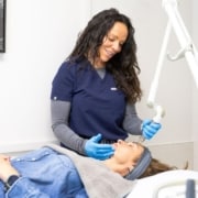 Skincare professional performing treatment in clinic with advanced equipment