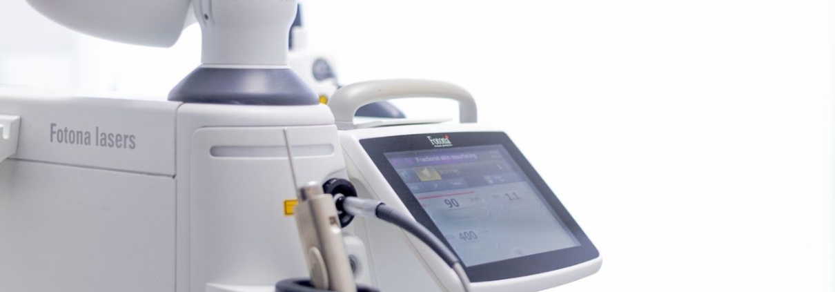 Close-up of a Fotona laser machine used for advanced skin and medical treatments, featuring a sleek touchscreen interface and precision handpiece.
