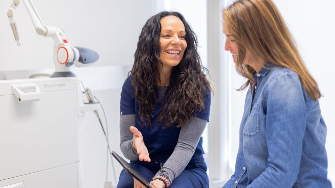 Professional explaining IPL treatment steps to a satisfied customer during consultation