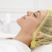 Woman receiving a facial treatment at a beauty clinic while lying on a treatment bed Woman receiving a facial treatment at a beauty clinic while lying on a treatment bed