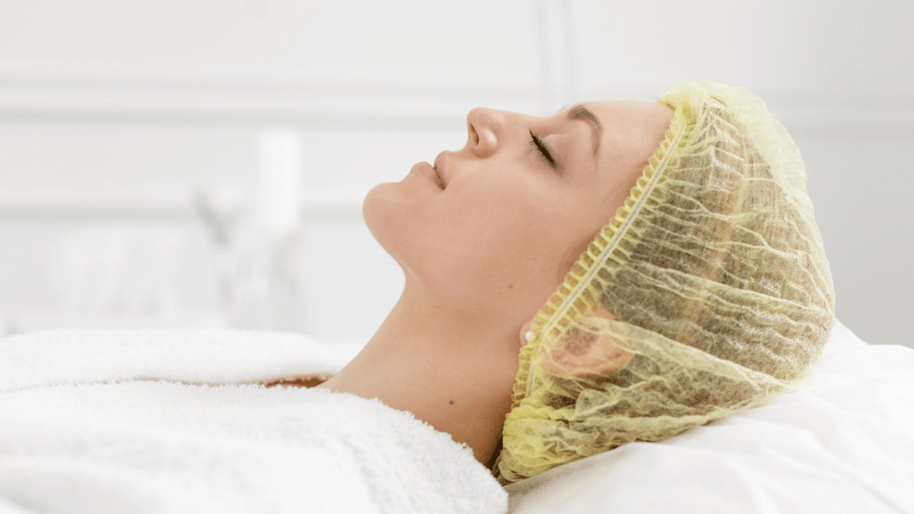 Woman receiving a facial treatment at a beauty clinic while lying on a treatment bed